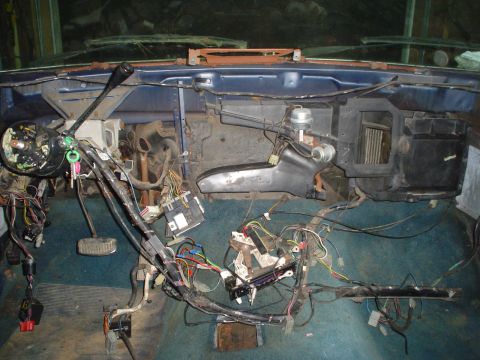 1984 Ford Bronco - The dashboard wiring of a vehicle is exposed for repair or modification.