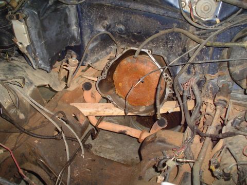 1984 Ford Bronco - The engine bay of a vehicle, focusing on the transmission bell housing and surrounding components, appears to be undergoing some form of re…