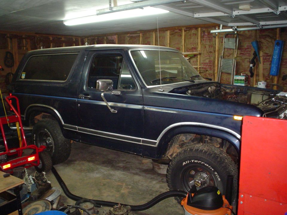 Dark blue Ford Bronco interior, hood open, in garage