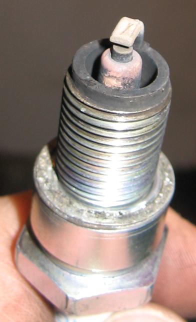 1990 Nissan Micra - A close-up view of a used spark plug, showing signs of wear on the electrode.