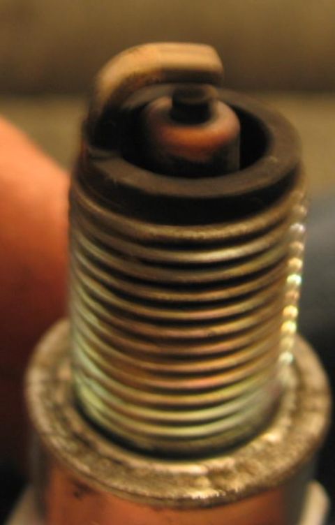 1990 Nissan Micra - A used spark plug shows signs of wear on its electrode and insulator tip.