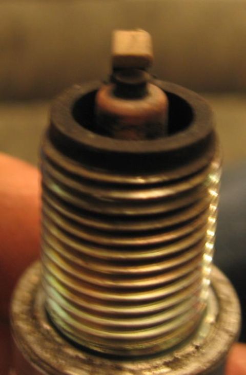 1990 Nissan Micra - Close-up of a spark plug, the SuperMotors.net logo at the bottom.