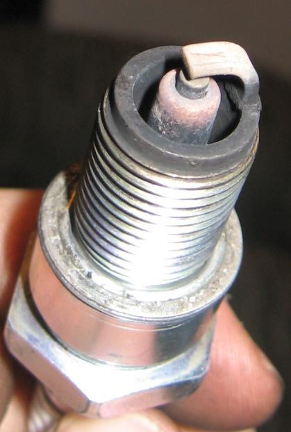 1990 Nissan Micra - A single spark plug, showing signs of wear and carbon buildup.