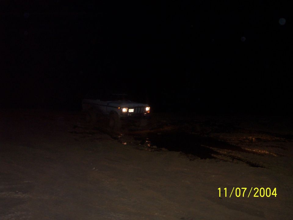 1978 Ford Bronco driving through mud at night