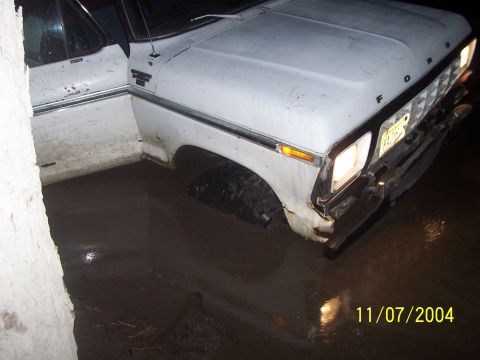 1979 Ford Bronco - This Ford truck is stuck in a muddy area with the driver's side door open.