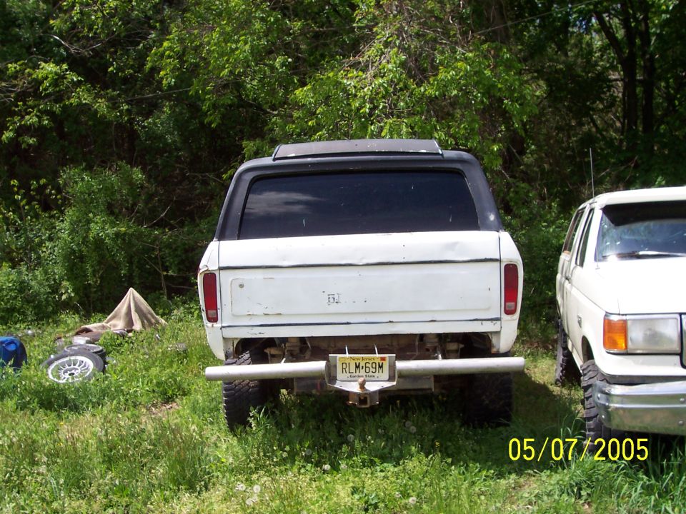 Rear view of a white SUV parked next to another white SUV. License plate is RLM-69M
