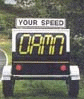 1996 Ford Probe - A portable speed display sign shows 'DAMN' in large yellow letters.