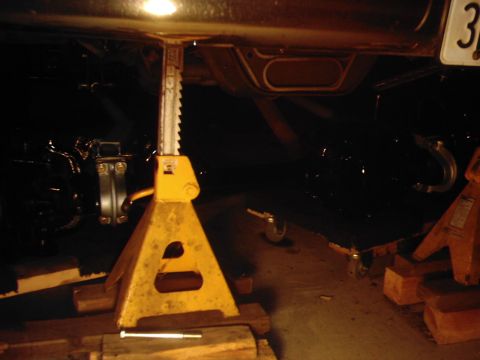 1978 Ford Bronco - Underbody view of a vehicle being worked on, supported by jack stands.