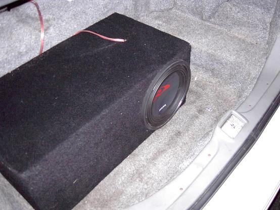 Carpeted subwoofer box with Alpine driver mounted in a vehicle trunk