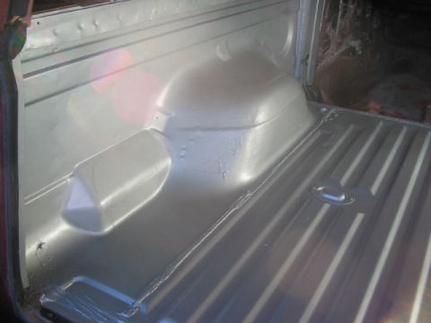 1991 Ford Bronco - The interior of a vehicle's cargo area is shown, with a focus on the floor and wheel well contours.