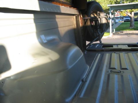 1991 Ford Bronco - Spare tire assembly mounted inside the cargo area of a vehicle.