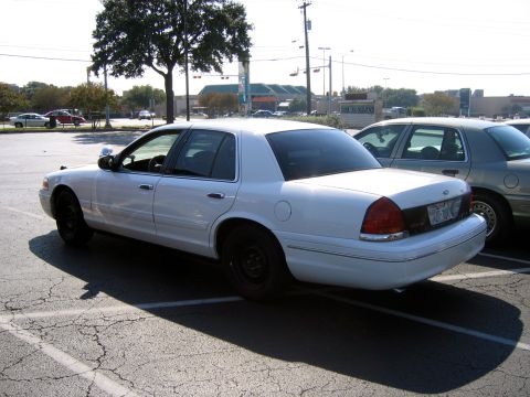 2000 Ford Crown Victoria - White 2000 Ford Crown Victoria parked in a lot with another car behind it.