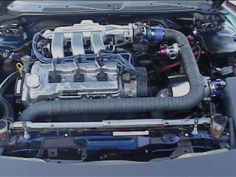 1994 Ford Probe - The engine bay of a car is shown, the V6 engine and various hoses and wires.