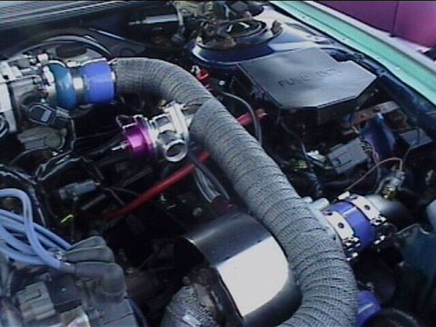 1994 Ford Probe - Close-up view of a modified engine bay, showing turbocharger components and wiring.