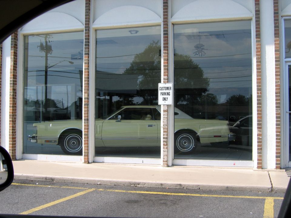Light yellow 1977 Ford Thunderbird coupe in showroom window