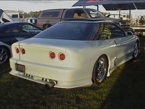 1994 Ford Probe - A modified 1994 Ford Probe is parked on grass next to other vehicles.