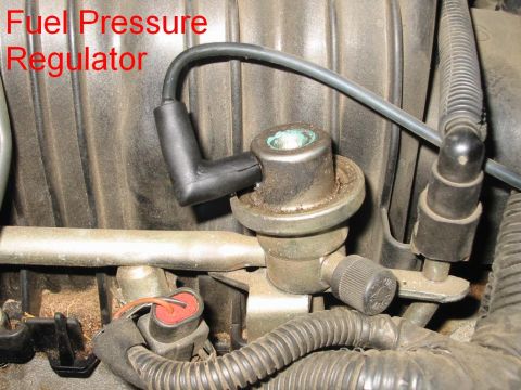 1997 Pontiac Grand Prix - Close-up of a fuel pressure regulator, a component of a vehicle's fuel system.