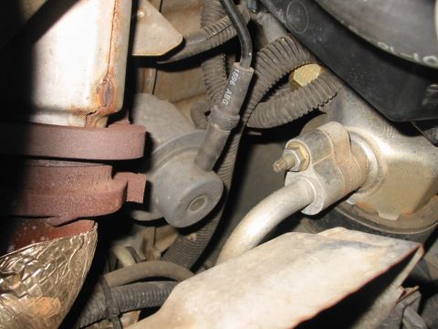 1997 Pontiac Grand Prix - A close-up view of various engine components, showing hoses, a manifold, and a labeled cable.