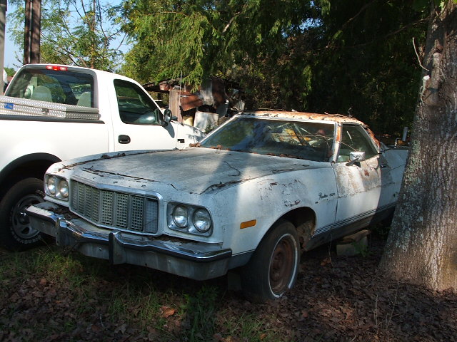 White 1977 Ford Ranchero front 3/4 view, parked next to a white pickup truck