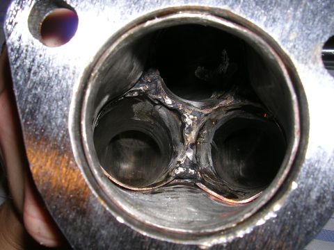 1996 Ford Probe - Close-up view of a worn exhaust manifold, highlighting the internal merging of four pipes and heat-induced damage.
