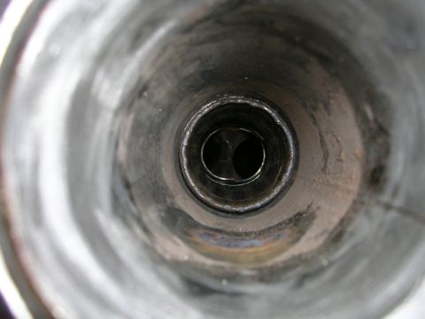 1996 Ford Probe - Close-up view looking into the dual openings of an exhaust pipe, showing welded seams and metallic interior.