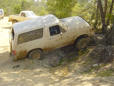 1989 Ford Bronco - This SUV is stuck in the mud on a sandy incline, with another vehicle visible in the background.