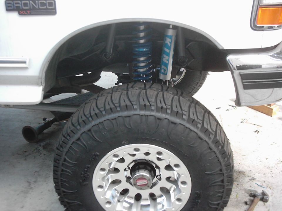 White Ford Bronco fender well with large tire and King shocks visible