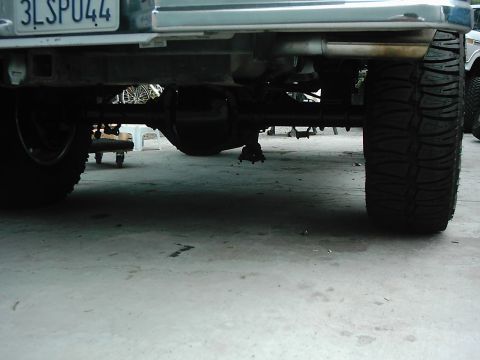 1978 Ford Bronco - Close-up view of a vehicle's rear axle and tire, with another vehicle partially visible in the background.