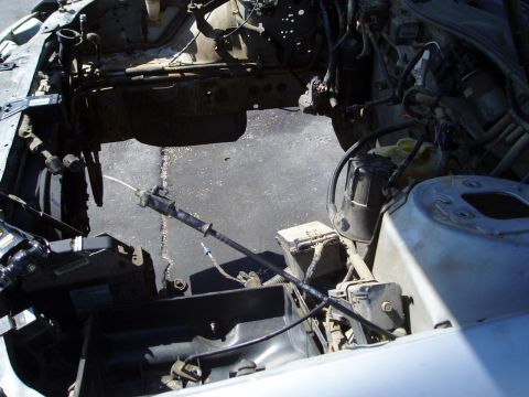 1993 Ford Taurus - The engine bay is largely empty, revealing the subframe and various mechanical components.