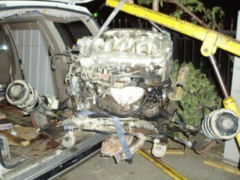1993 Ford Taurus - Engine and front subframe assembly removed from a vehicle, likely for repair or replacement.
