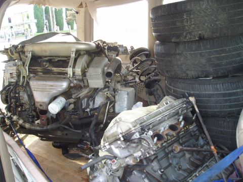 1993 Ford Taurus - Engine and tires loaded into a vehicle, with an additional engine block in the foreground.