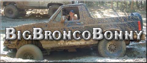1993 Ford Bronco - This Bronco is covered in mud while off-roading. A second vehicle is visible in the background.