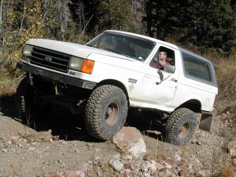 1994 Ford Bronco - This 1987 Ford Bronco navigates a challenging off-road course with a driver visible inside.