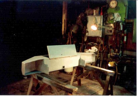 1989 Ford Bronco - Workshop scene with a white fiberglass part on sawhorses, surrounded by tools and equipment.