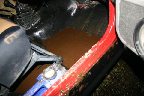 2003 Jeep TJ - The interior of a 2003 Jeep TJ shows significant mud accumulation on the floor and door sill.