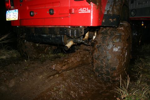 2003 Jeep TJ - Jeep TJ with '4.0L' badging is stuck deep in mud, license plate EGK 590 visible.