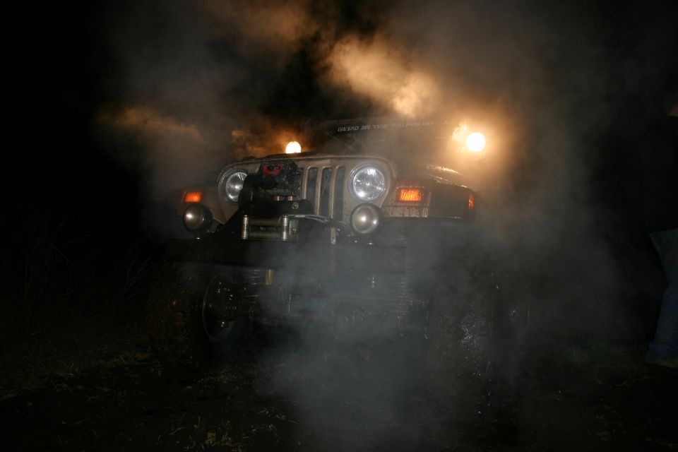 Front view of a Jeep Wrangler in smoke, with headlights on