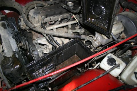 2003 Jeep TJ - The engine bay of a 2003 Jeep TJ shows signs of oil leaks and a soiled air filter housing.