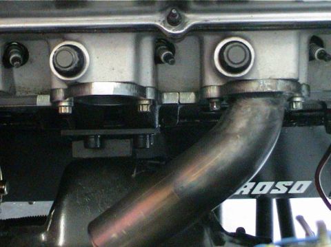 1979 Ford Bronco - Close-up view of engine components, including a manifold and cylinder head, with visible text on a black surface.