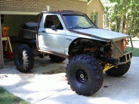 1985 Ford Bronco - This heavily modified pickup truck features a custom roll cage and massive off-road tires, suggesting a focus on extreme terrain capability.