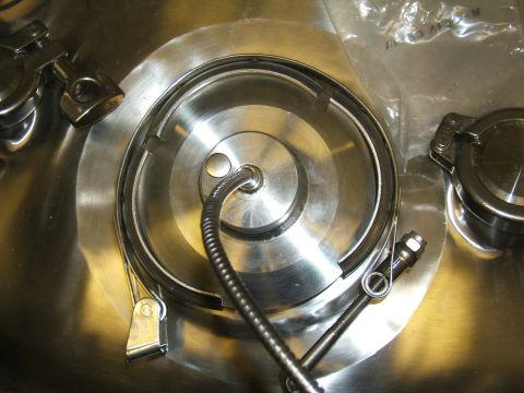 1998 Ford Taurus - A close-up view of a metal component, possibly part of a larger system, with a flexible hose and securing clamps visible.