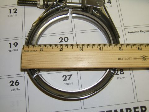 1998 Ford Taurus - A metal exhaust clamp is measured with a ruler on a calendar page.