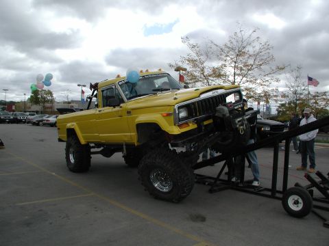 1977 Ford F-150 - A modified yellow Jeep pickup truck is positioned on a camera dolly, possibly for filming.