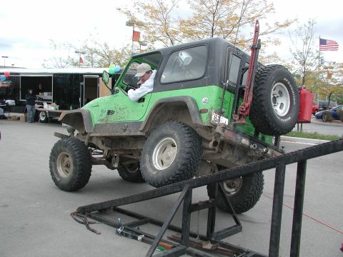 1977 Ford F-150 - Modified Jeep Wrangler on an obstacle course ramp, equipped with off-road tires and accessories.