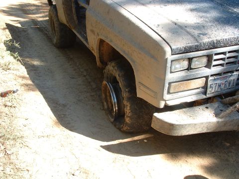 1993 Ford Bronco - The vehicle has a flat tire and appears to be off-road.