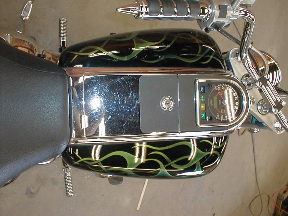 Cruiser motorcycle tank with green flames, chrome trim and tank-top speedometer