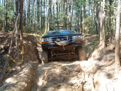 1993 Ford Bronco - Ford Bronco tackling a challenging muddy obstacle on an off-road course.