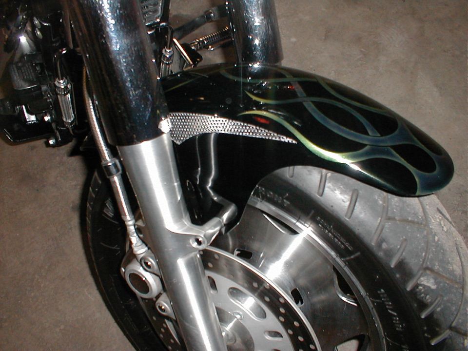 Black motorcycle fender with green and blue flame graphics and chrome accents