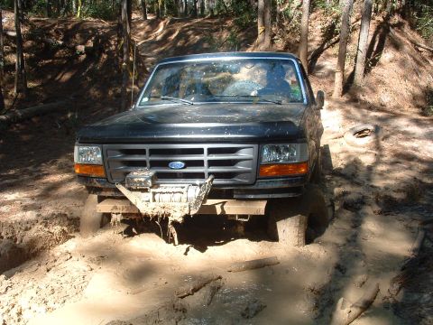 1993 Ford Bronco - Ford Bronco navigating a muddy off-road trail.