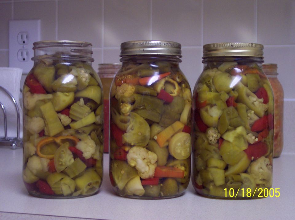 Three jars of pickled vegetables on a counter, with a date stamp '10/18/2005' and 'SUPERMOTORS' logo at the bottom